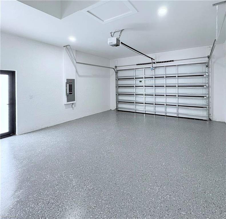 Garage featuring electric panel and a garage door opener