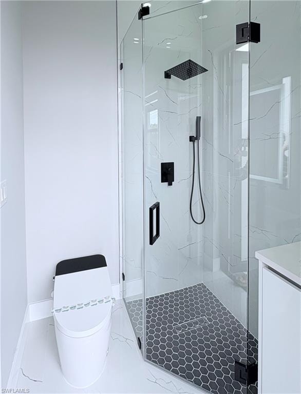 Full bath with a marble finish shower and vanity