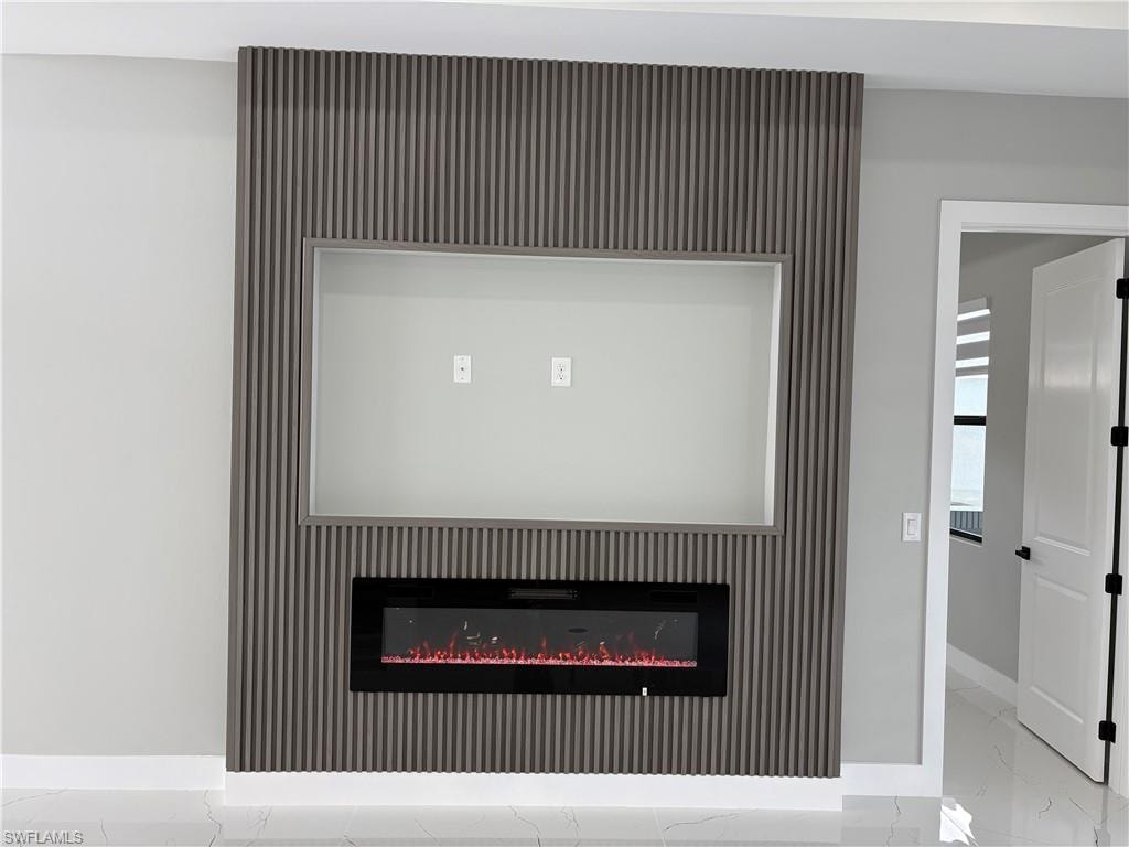 Detailed view of a glass covered fireplace and an accent wall