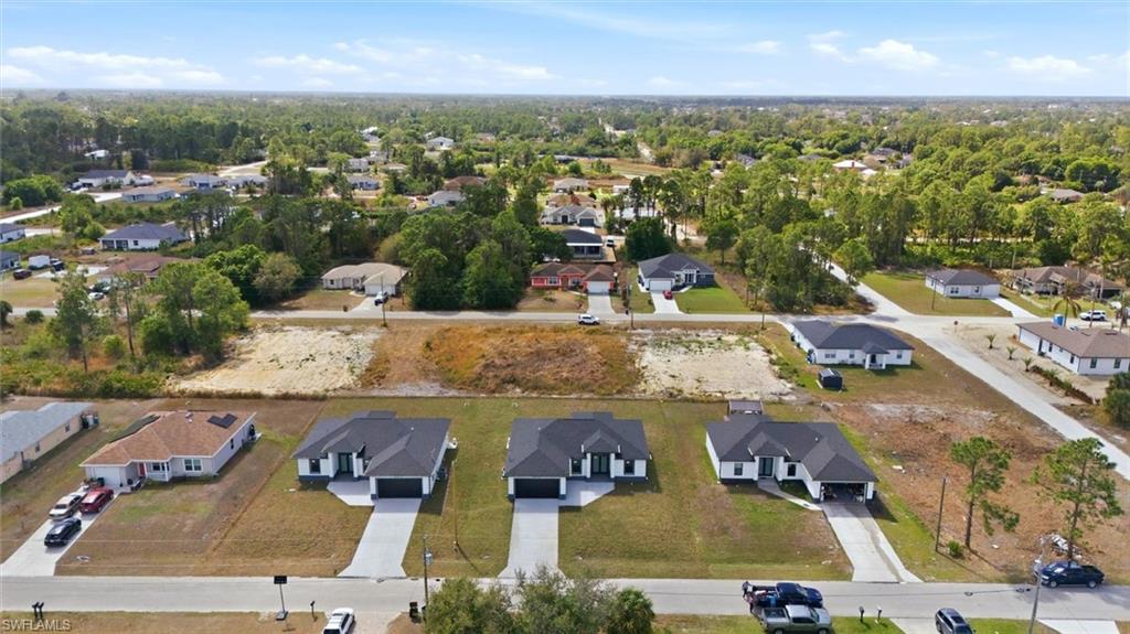 Aerial view of property and surrounding area with nearby suburban area