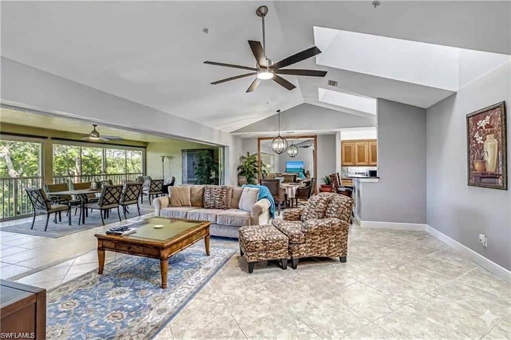 Spacious living area featuring vaulted ceilings, 3 skylights tileflooring, and a contemporary ceiling fan
