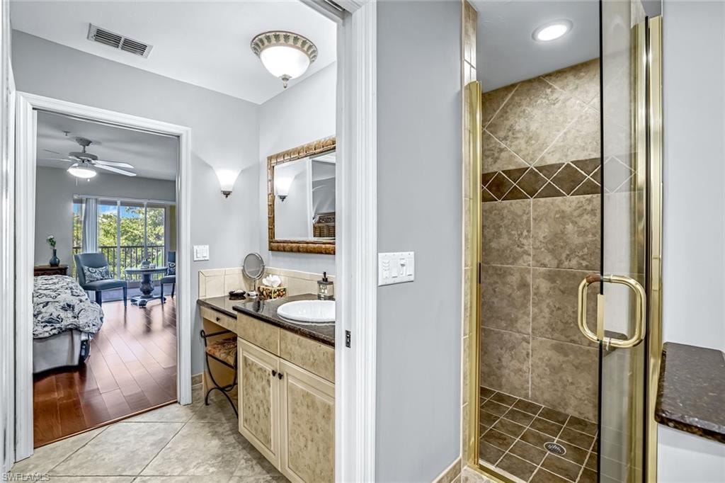 Second ensuite bathroom vanity, a shower stall and a ceiling fan