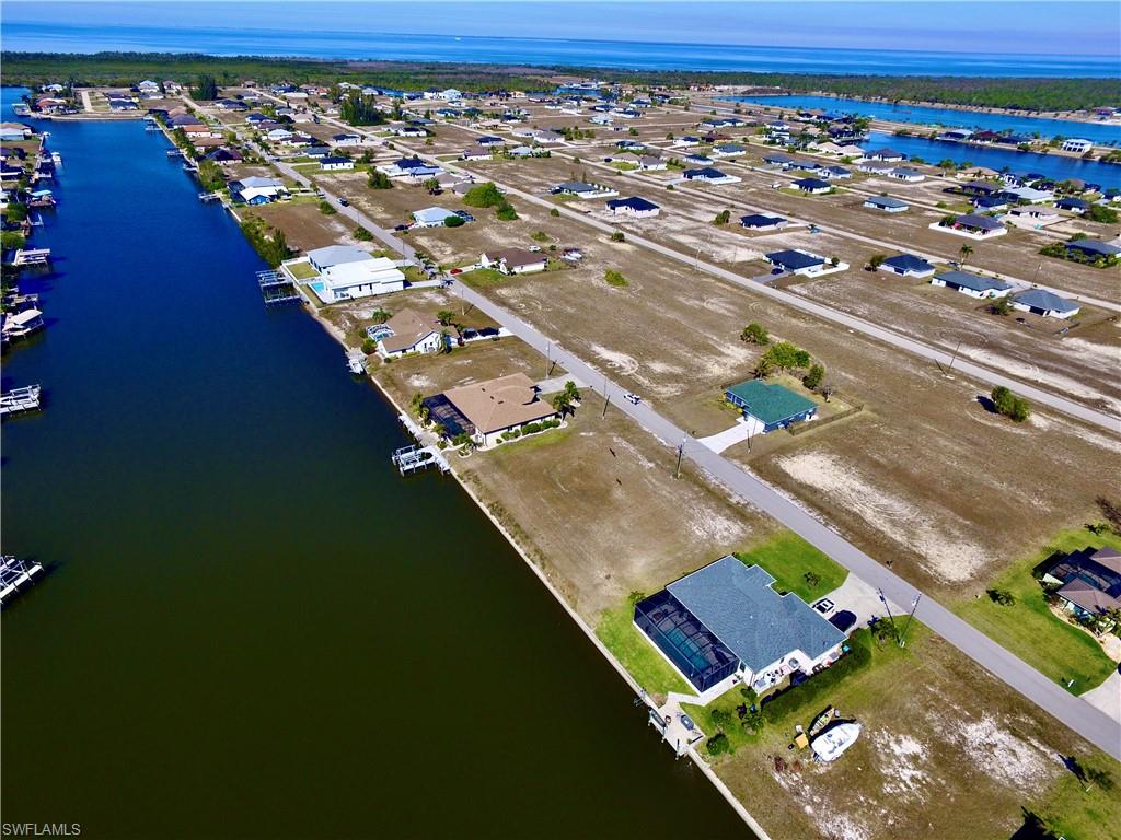 Aerial perspective of suburban area featuring a nearby body of water