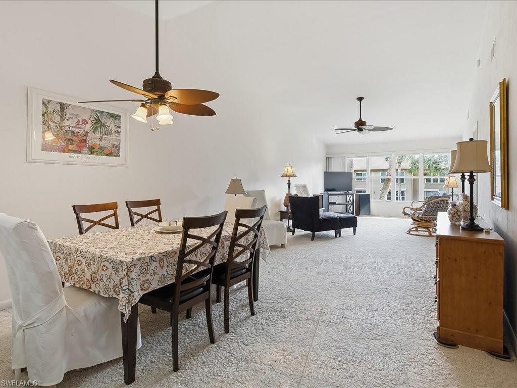 Dining room with light carpet and a ceiling fan