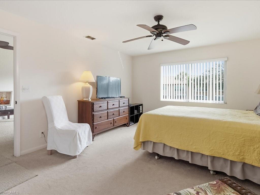 Carpeted bedroom featuring a ceiling fan