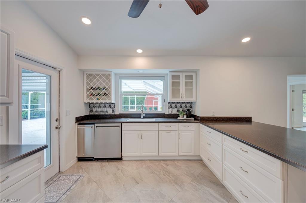 Kitchen with stainless steel dishwasher, glass insert cabinets, white cabinetry, ceiling fan, and recessed lighting