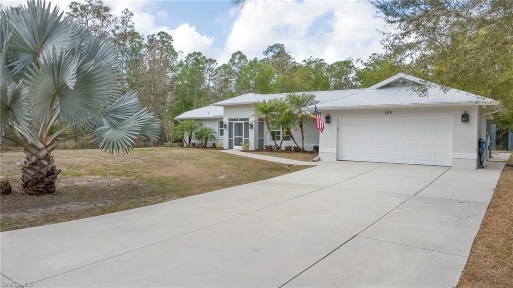 Single story home with a front yard, a garage, concrete driveway, and stucco siding