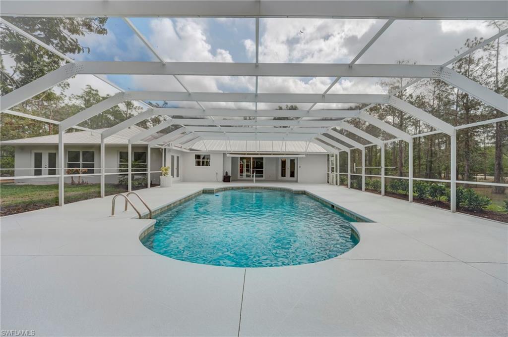 Outdoor pool with a sunroom, a lanai, and a patio area