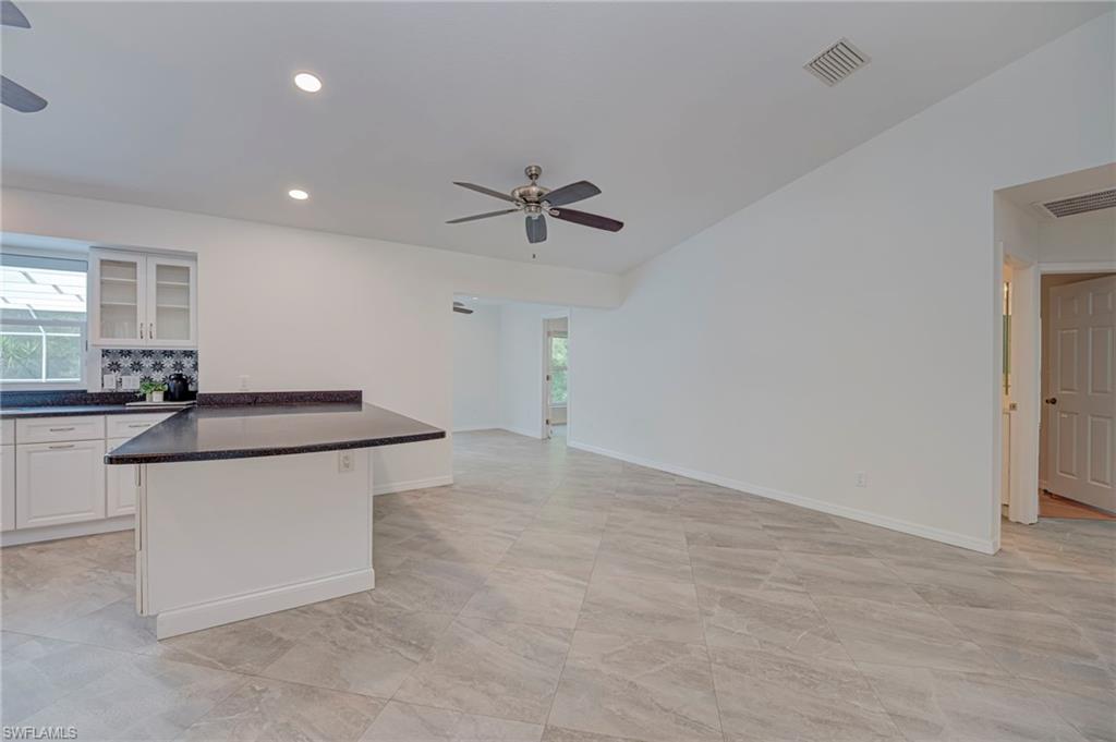 Kitchen featuring glass insert cabinets, a ceiling fan, white cabinetry, healthy amount of natural light, and recessed lighting