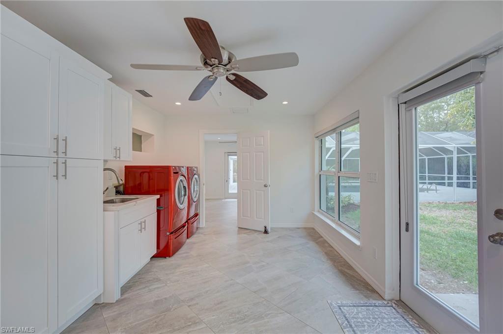 Kitchen featuring white cabinetry, light countertops, ceiling fan, washing machine and dryer, and recessed lighting