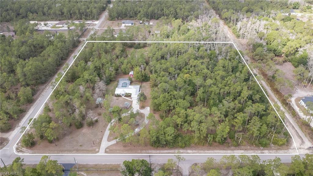 Aerial view of property's location with a heavily wooded area and property boundaries highlighted