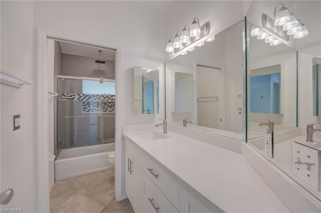 Bathroom with vanity and a combined bath / shower with rainfall shower