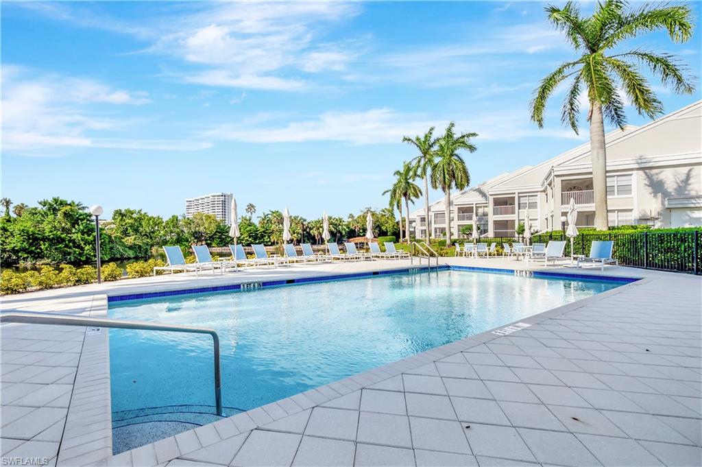 Heated Community Pool with large deck area, lounge chairs and umbrellas