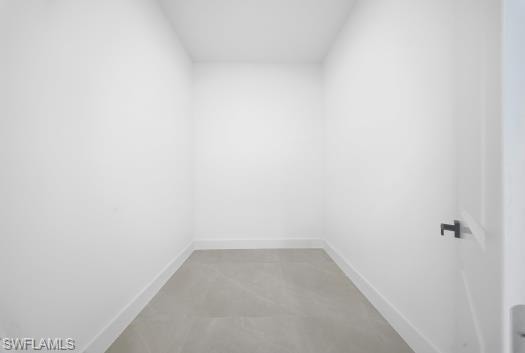 Unfurnished room featuring baseboards and finished concrete flooring