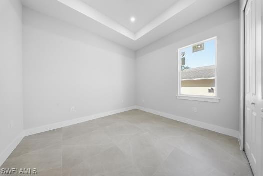 Unfurnished room featuring a raised ceiling and recessed lighting
