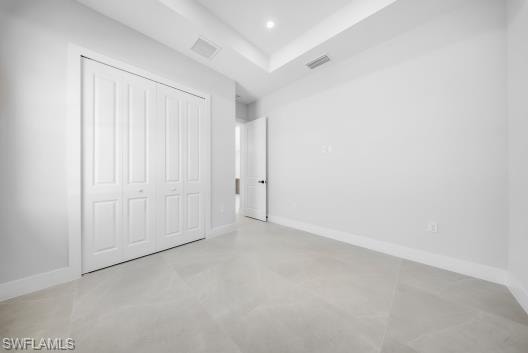 Unfurnished bedroom featuring finished concrete flooring, a closet, and recessed lighting