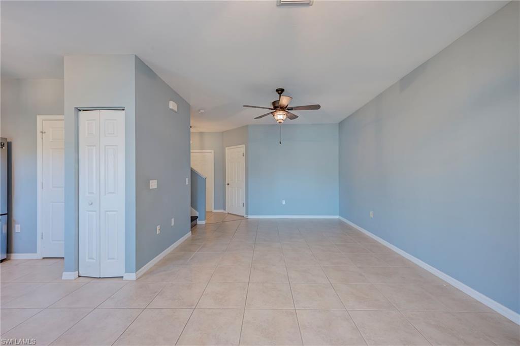 Empty room with a ceiling fan and light tile patterned floors
