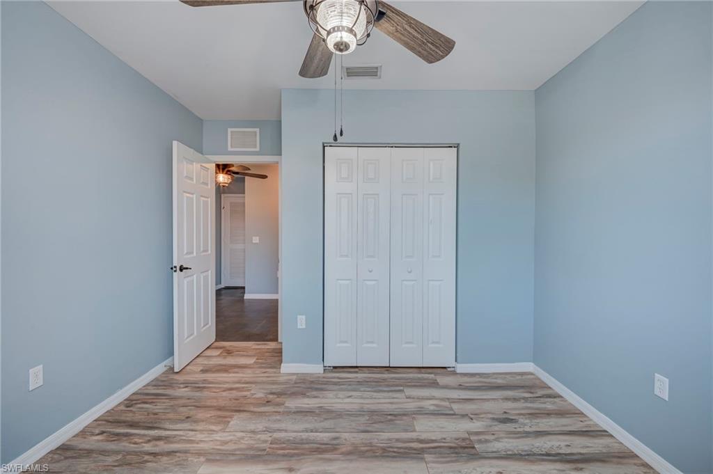 Unfurnished bedroom with light wood-style flooring, a closet, and ceiling fan