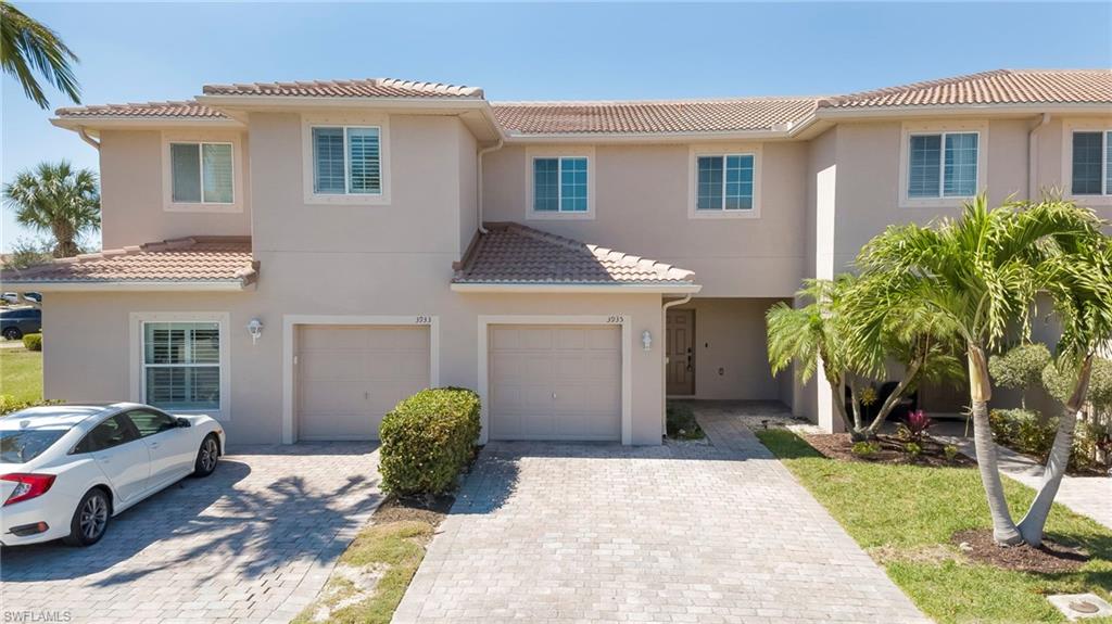 Mediterranean / spanish-style home featuring a garage, stucco siding, decorative driveway, and a tiled roof