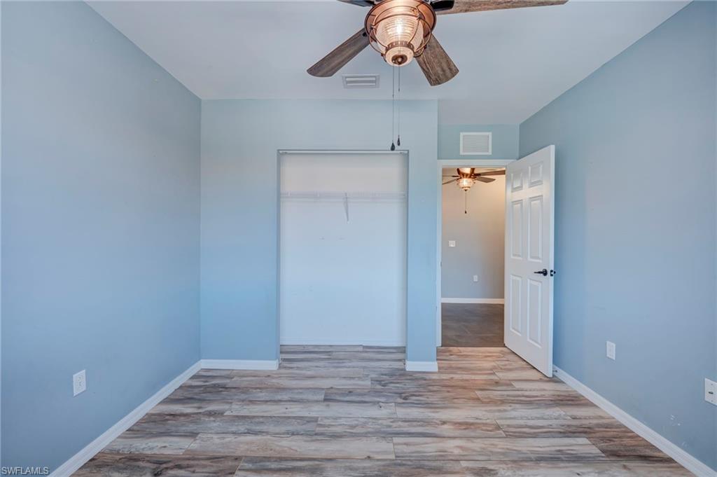 Unfurnished bedroom featuring light wood-style flooring, a closet, and ceiling fan