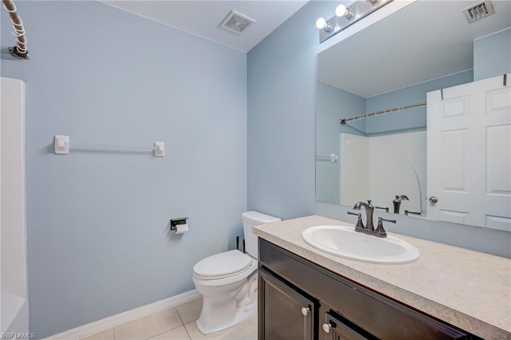 Full bath with vanity and light tile patterned floors