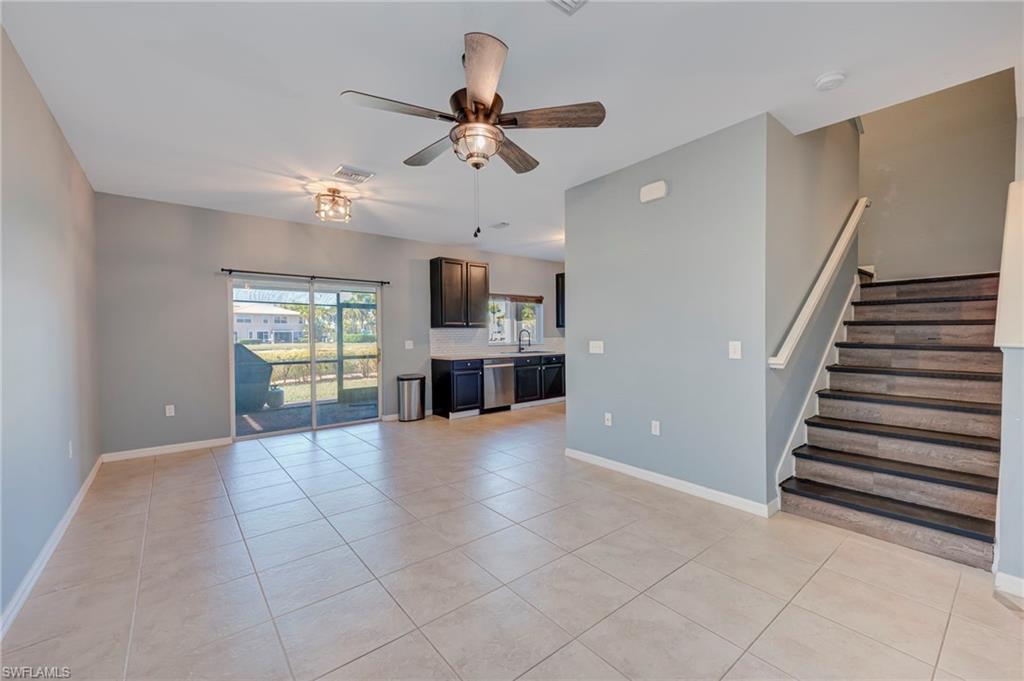 Unfurnished living room with ceiling fan and light tile patterned floors