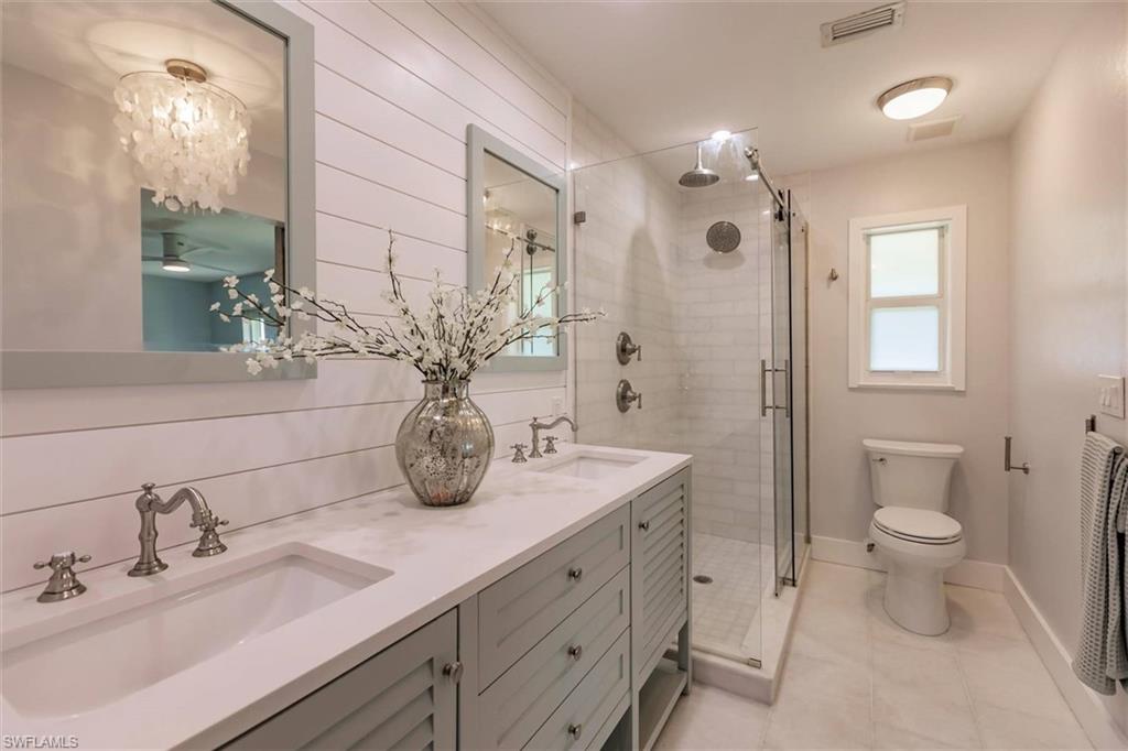 Full bathroom featuring a stall shower, a sink, and visible vents