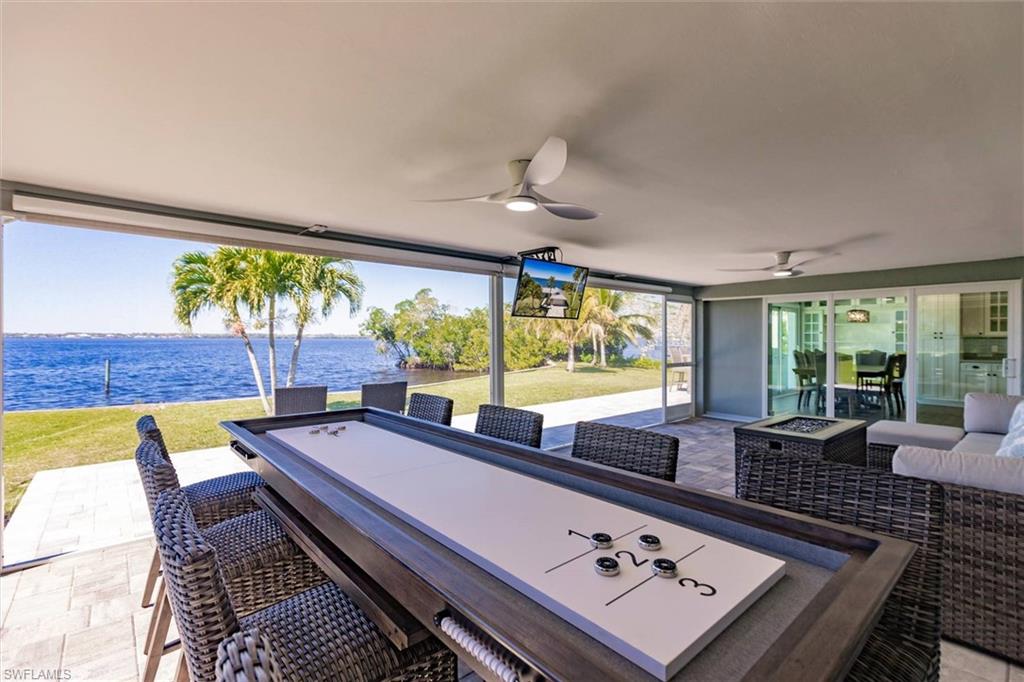 View of patio with an outdoor living space with a fire pit and ceiling fan