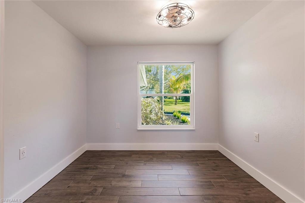 Empty room with dark wood-style floors and baseboards