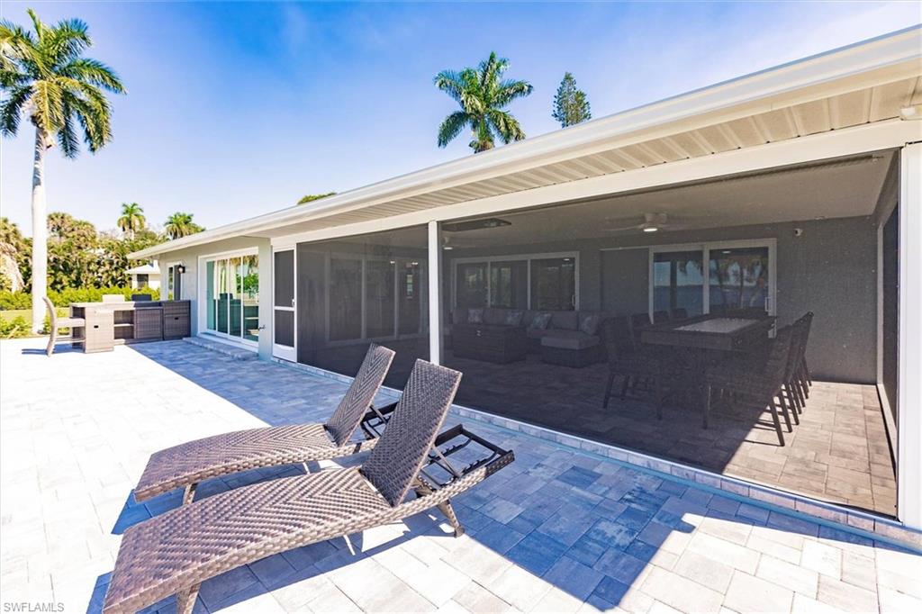 View of patio featuring ceiling fan, outdoor dining space, and a sunroom