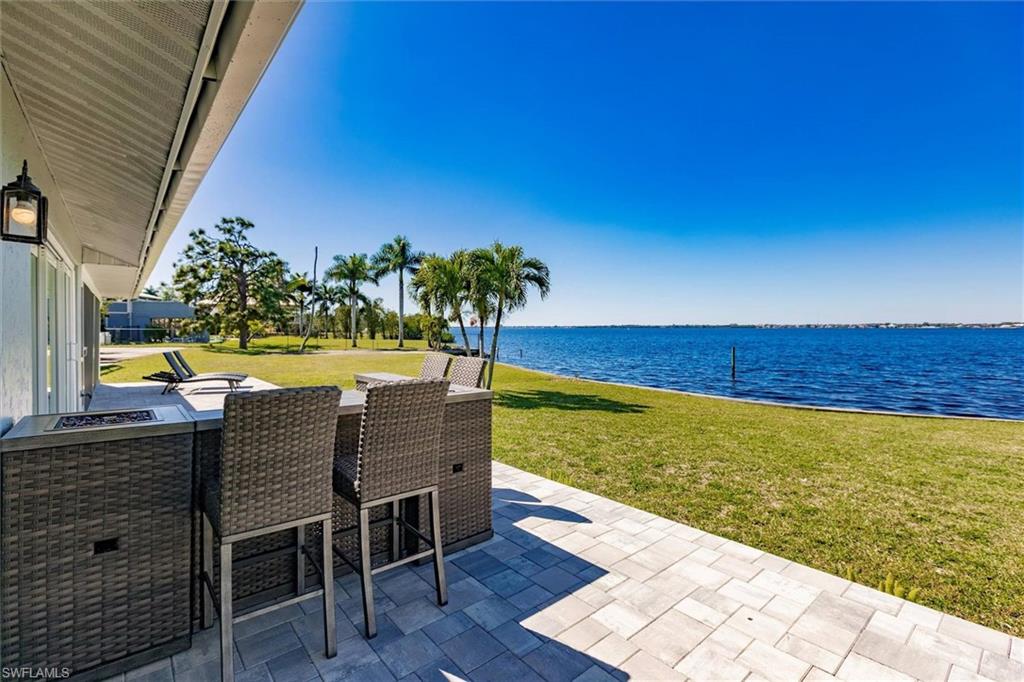 View of patio with a water view and an outdoor bar