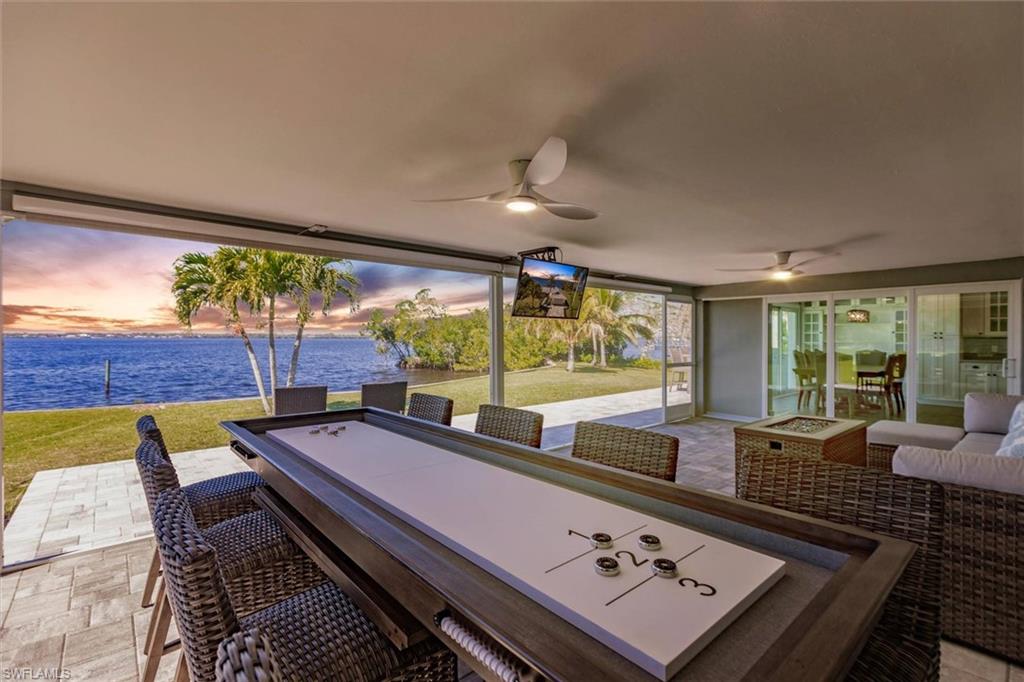 Patio terrace at dusk featuring an outdoor hangout area, a lawn, and a ceiling fan
