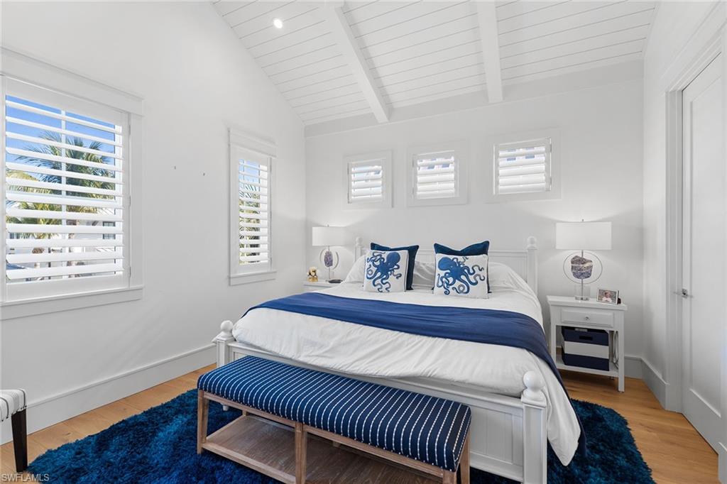 Bedroom featuring light wood-style floors, vaulted ceiling with beams, and wood ceiling