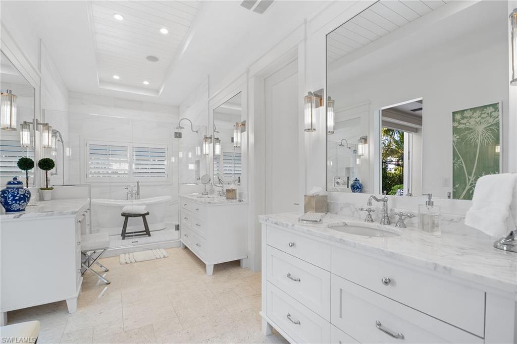 Bathroom with two vanities, a freestanding bath, recessed lighting, a stall shower, and wooden ceiling