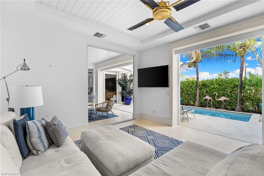 Living area with ceiling fan, wood ceiling, and tile patterned floors