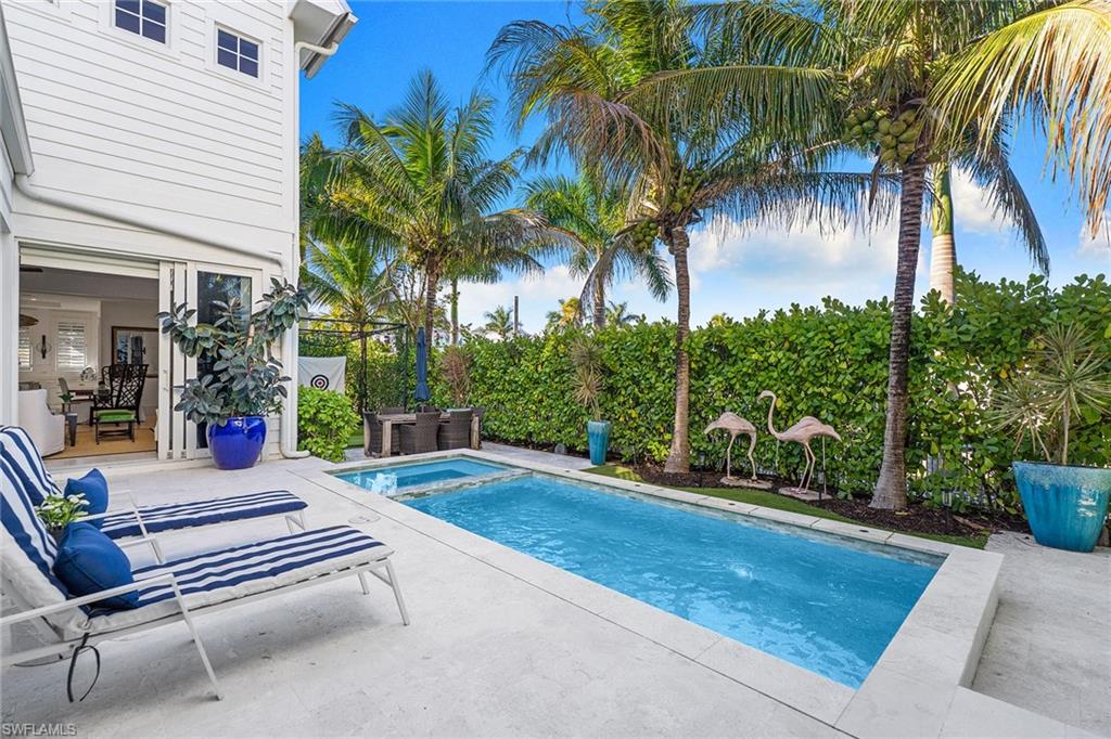 Combined pool / hot tub with a patio area and a fenced backyard