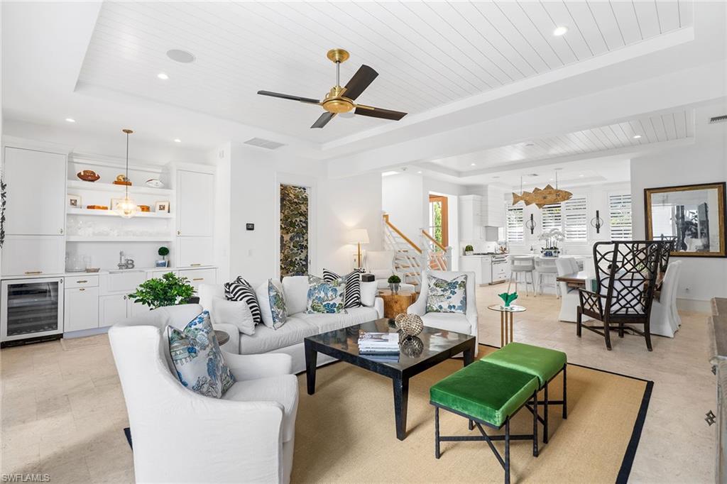 Living area featuring a wood tray ceiling, wine cooler, recessed lighting, a dry bar, and ceiling fan