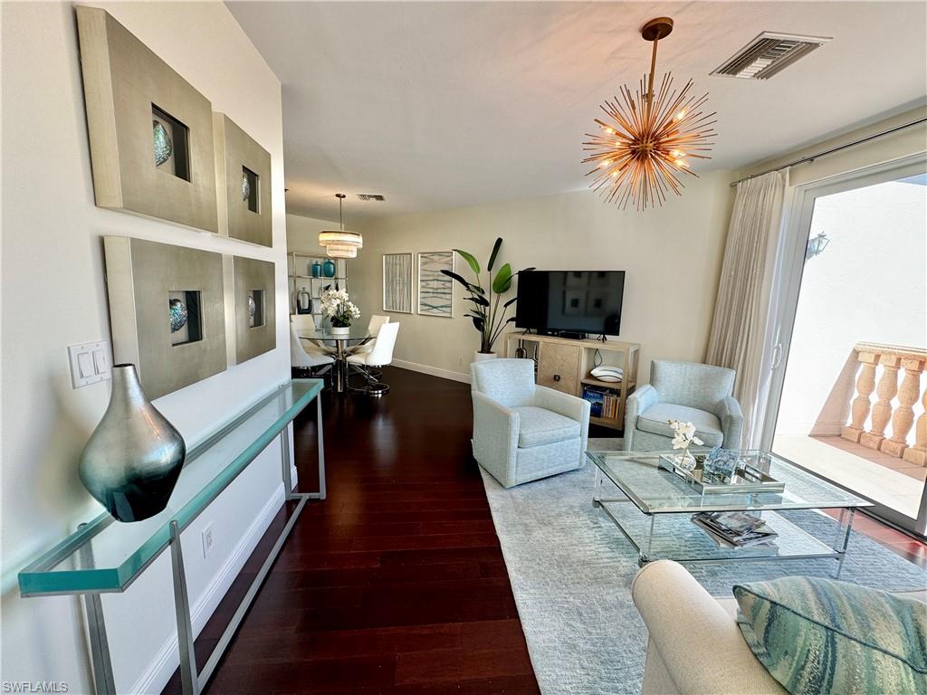 Living room featuring an inviting chandelier and dark hardwood / wood-style flooring