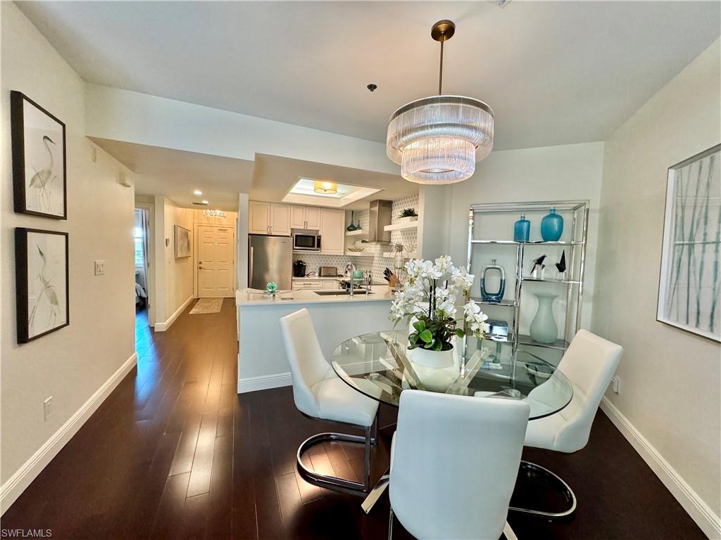 Dining space featuring sink, a chandelier, and dark hardwood / wood-style flooring