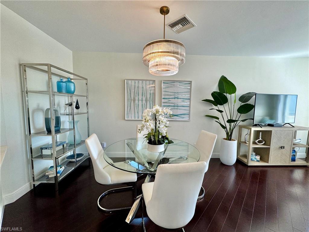 Dining area featuring an inviting chandelier and dark hardwood / wood-style flooring