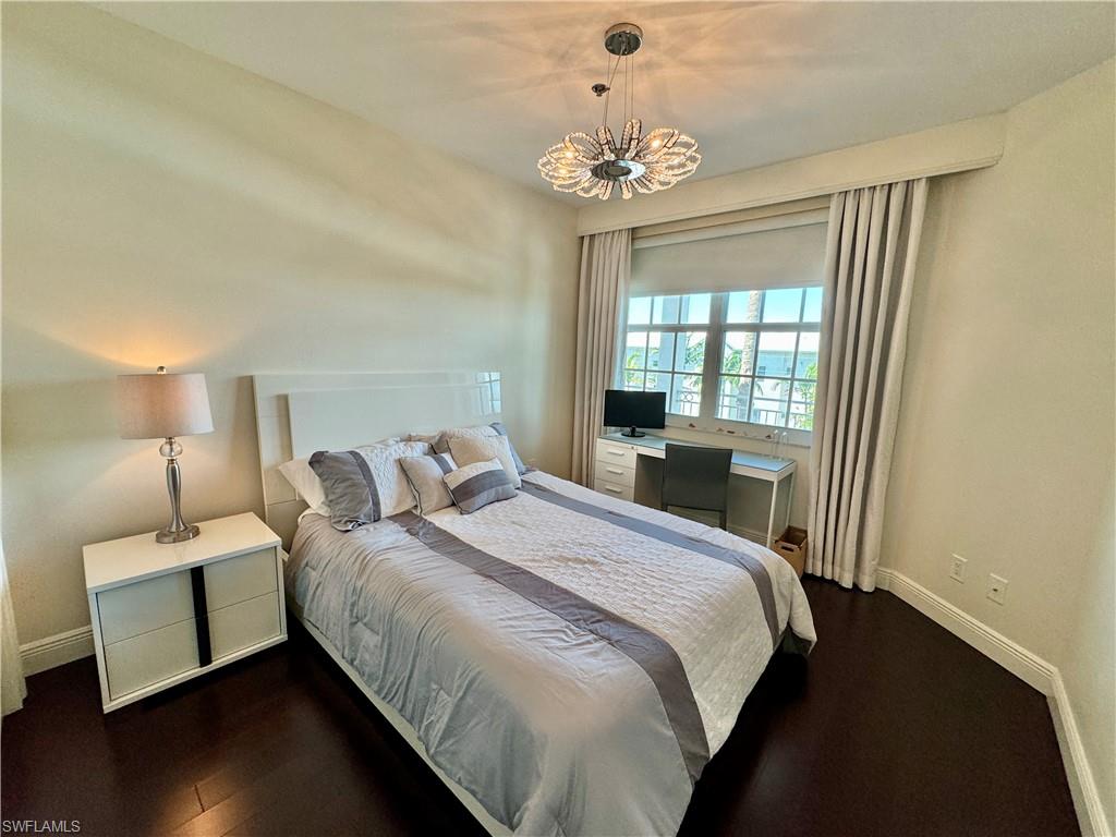 Bedroom featuring dark hardwood / wood-style floors and an inviting chandelier