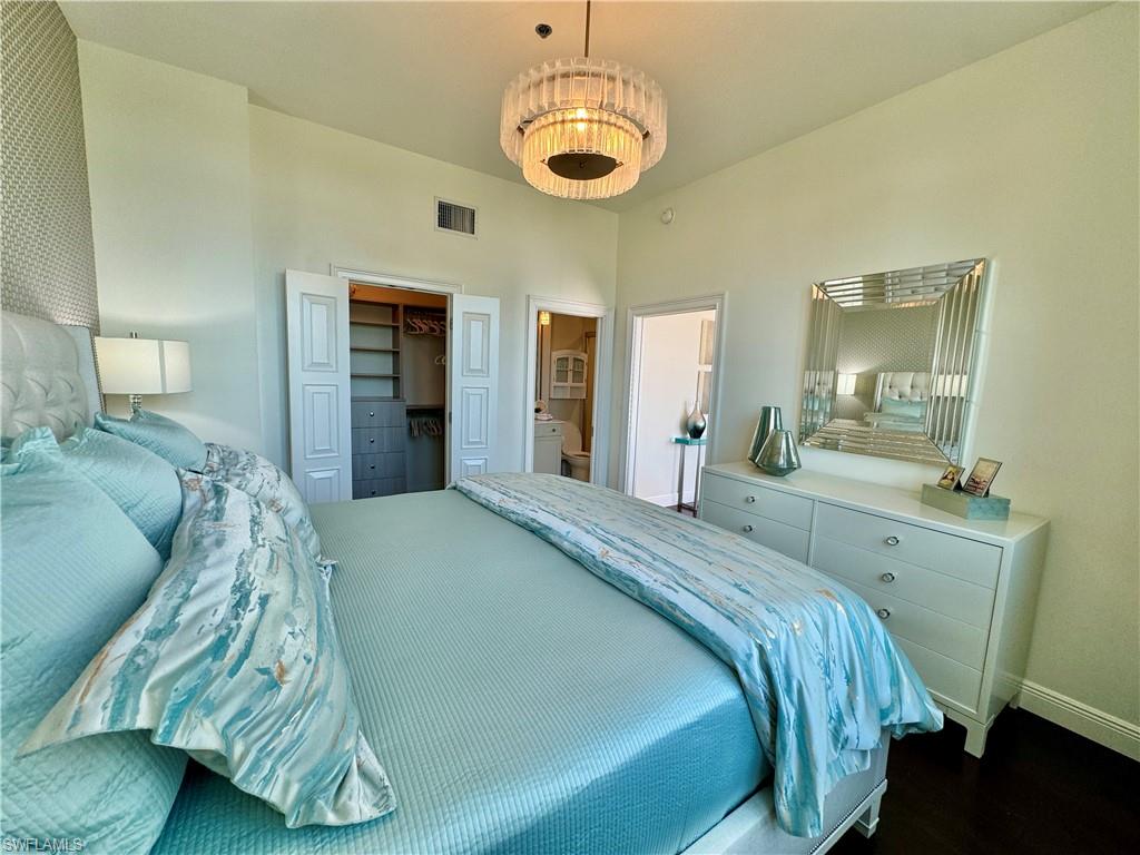 Bedroom featuring a closet, ensuite bath, and dark hardwood / wood-style flooring