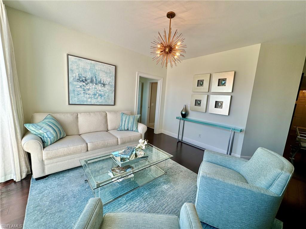 Living room featuring a notable chandelier and dark wood-type flooring
