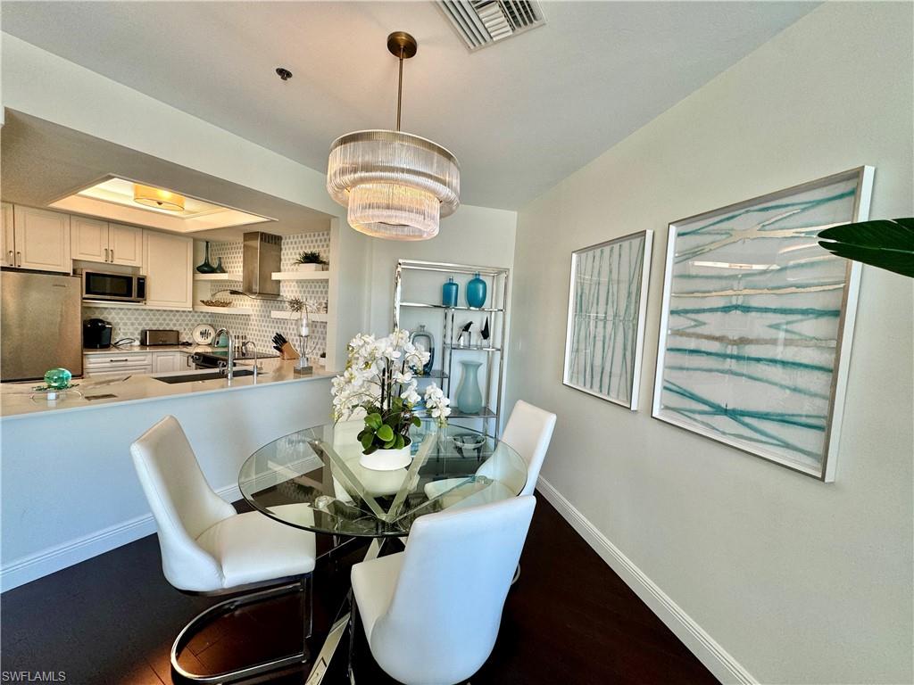 Dining space with hardwood / wood-style flooring and an inviting chandelier