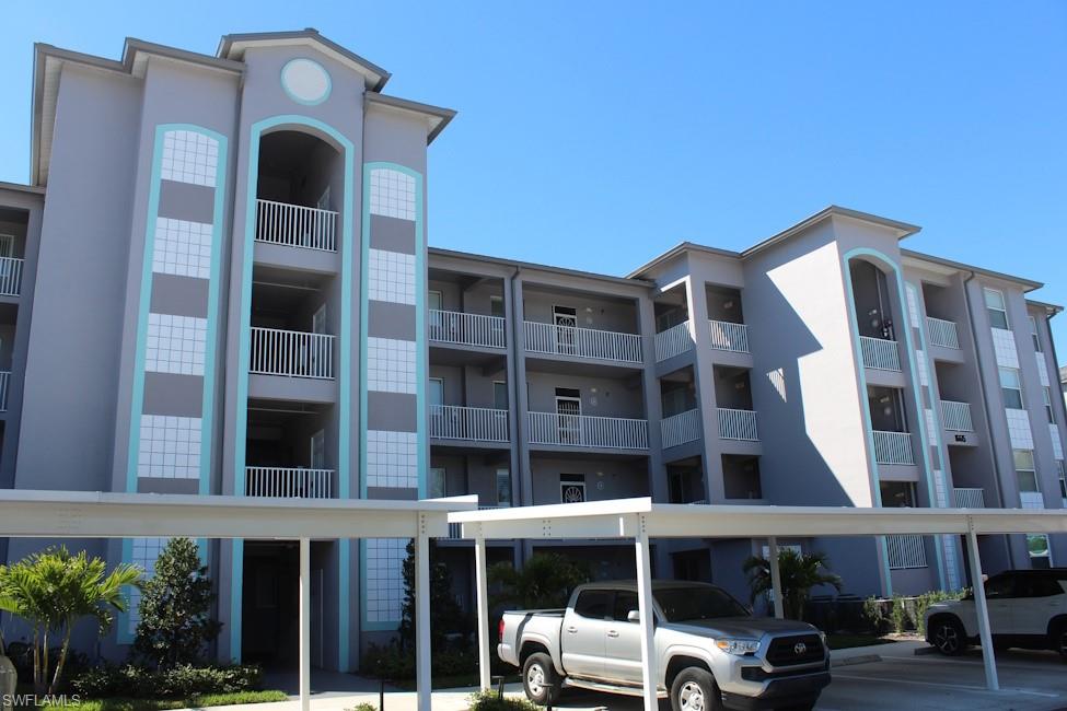 View of apartment building / complex with covered parking