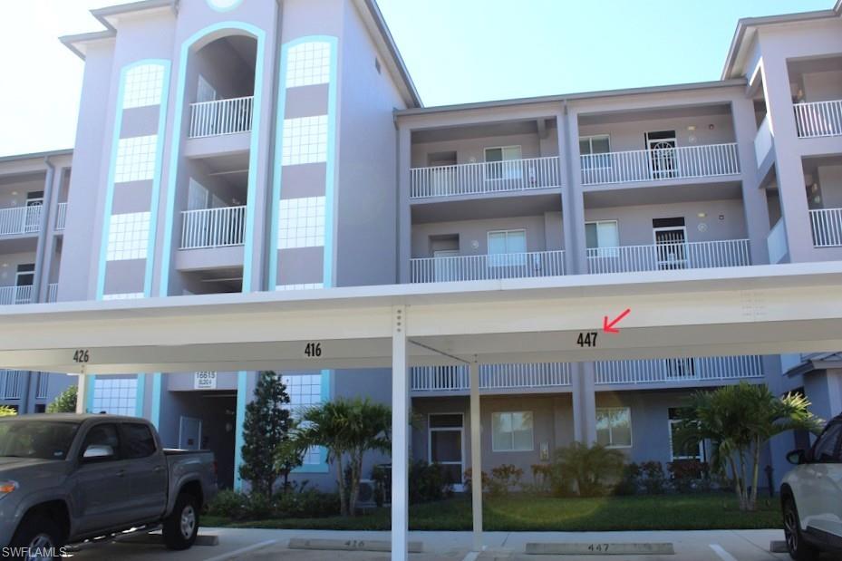 View of apartment building / complex with covered parking