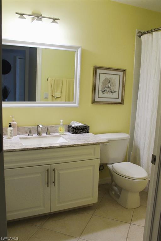 Bathroom with vanity, a shower with curtain, and light tile patterned flooring