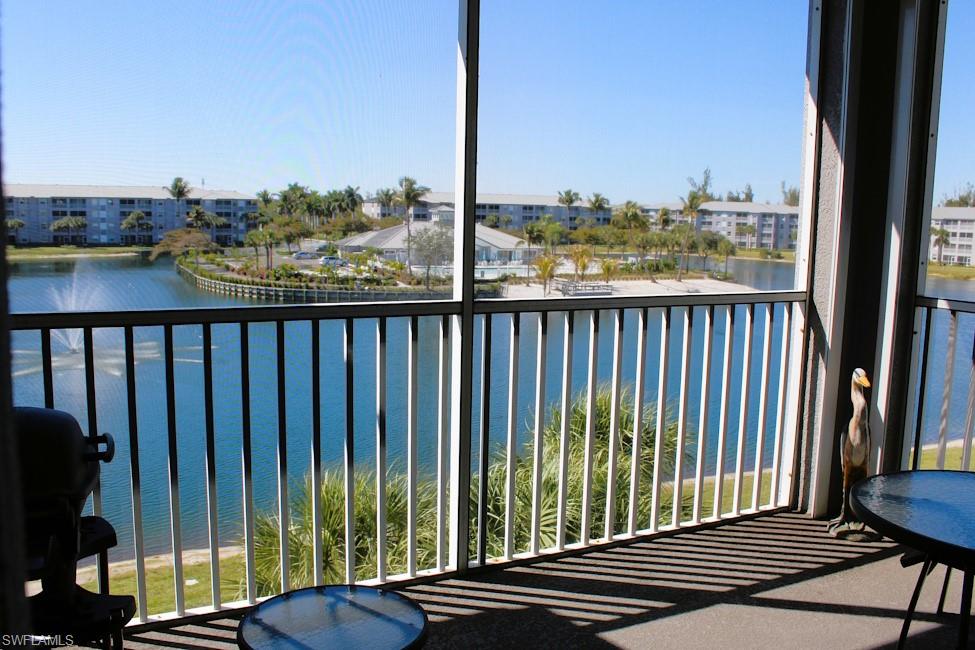 Balcony featuring a water view, a sunroom, and a grill