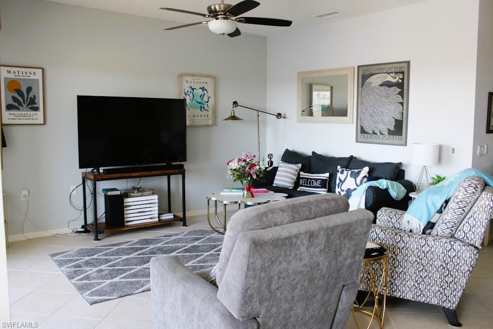 Living area featuring tile patterned floors and ceiling fan