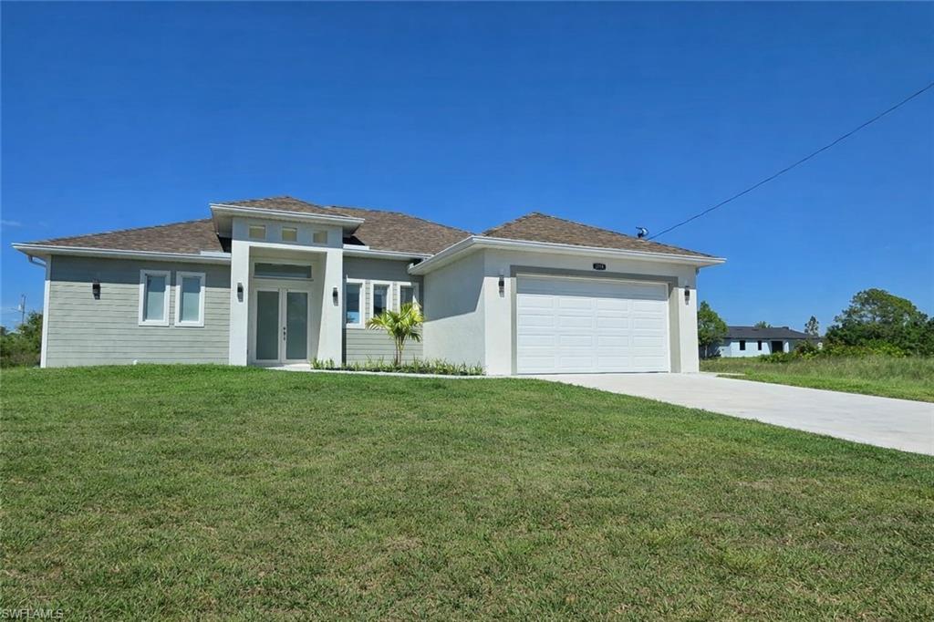 Prairie-style home with a front lawn, driveway, and an attached garage